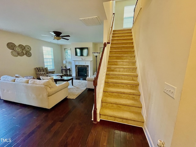 living room featuring ceiling fan and dark hardwood / wood-style flooring