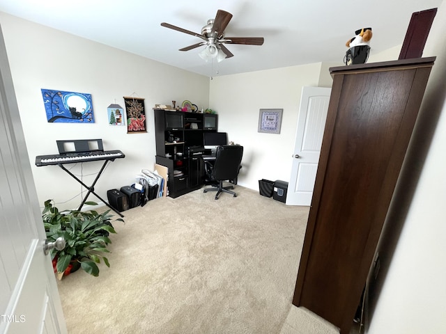 carpeted office featuring ceiling fan