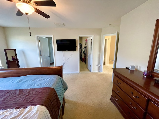 carpeted bedroom with a spacious closet and ceiling fan