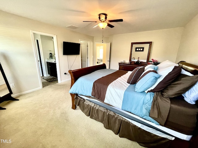 bedroom with connected bathroom, light colored carpet, and ceiling fan