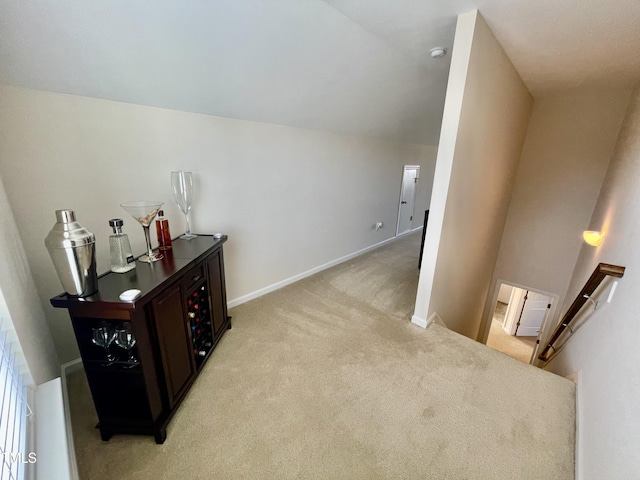 hall featuring light carpet and vaulted ceiling