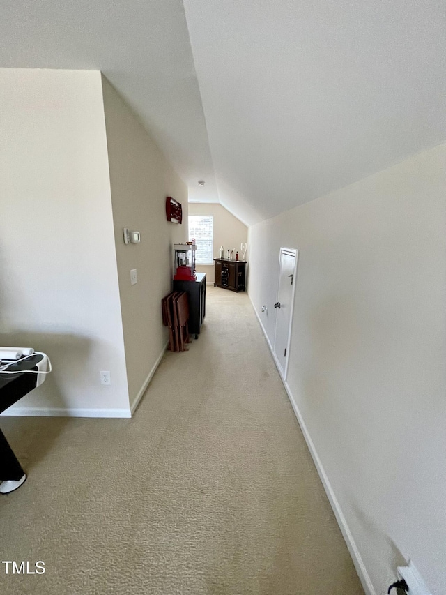 corridor featuring vaulted ceiling and carpet