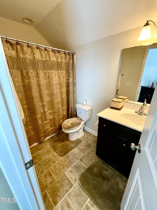 bathroom with vanity, lofted ceiling, and toilet