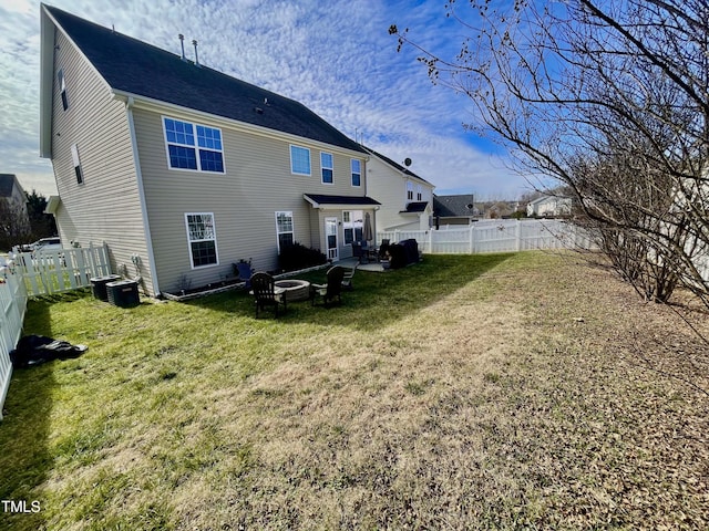 back of house featuring an outdoor fire pit, a lawn, and central air condition unit