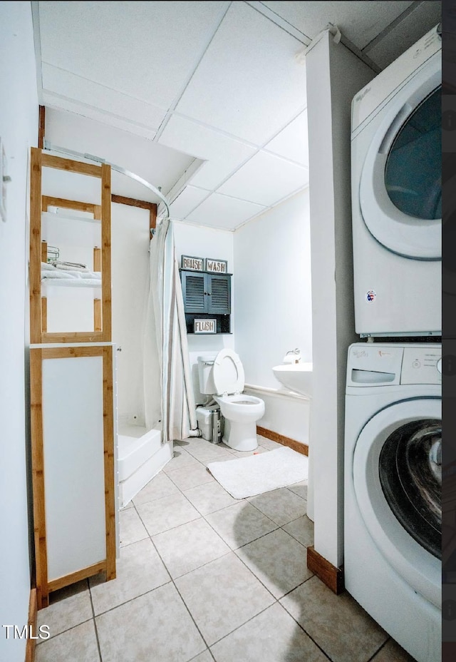 washroom with tile patterned flooring, sink, and stacked washer / dryer