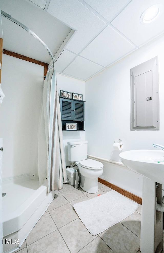 bathroom with curtained shower, electric panel, tile patterned floors, and toilet