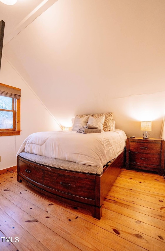 bedroom with light hardwood / wood-style flooring and vaulted ceiling