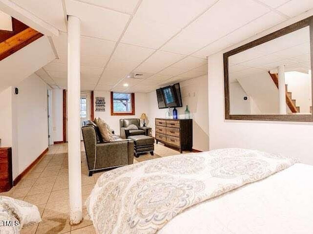 bedroom with a paneled ceiling and light tile patterned floors