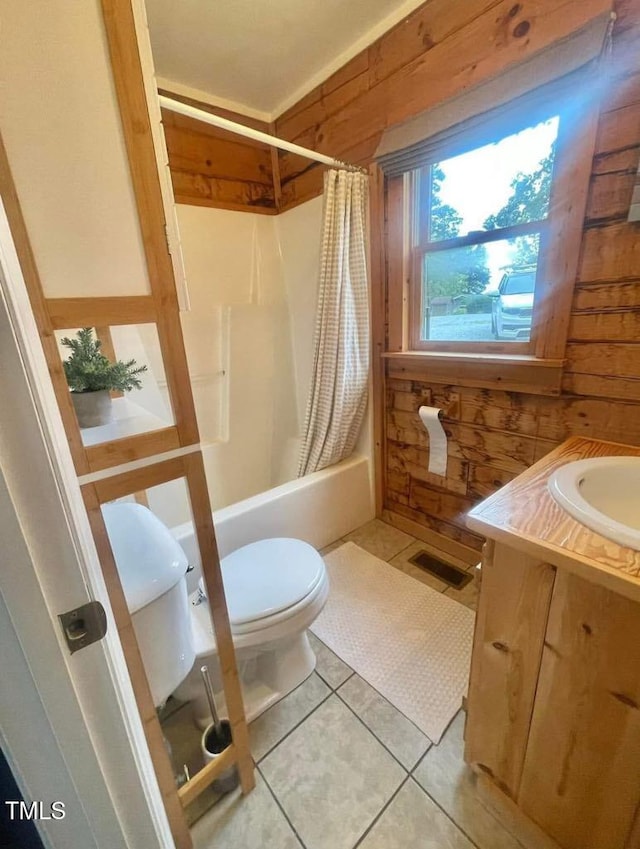 full bathroom featuring tile patterned flooring, wood walls, vanity, toilet, and shower / bath combo with shower curtain