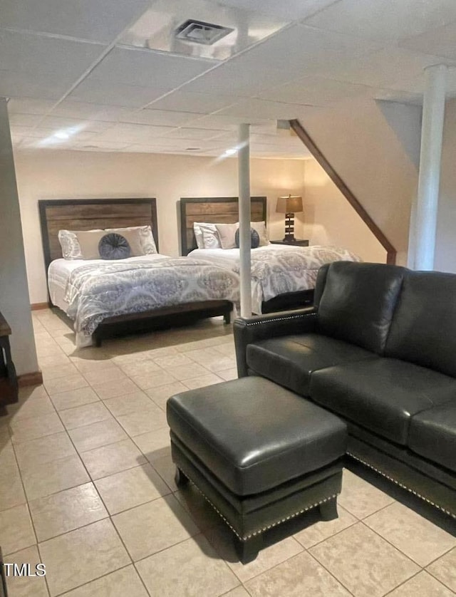 tiled bedroom featuring a drop ceiling