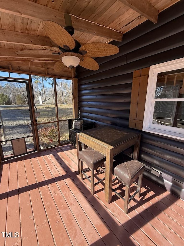 unfurnished sunroom featuring beam ceiling, wooden ceiling, and ceiling fan