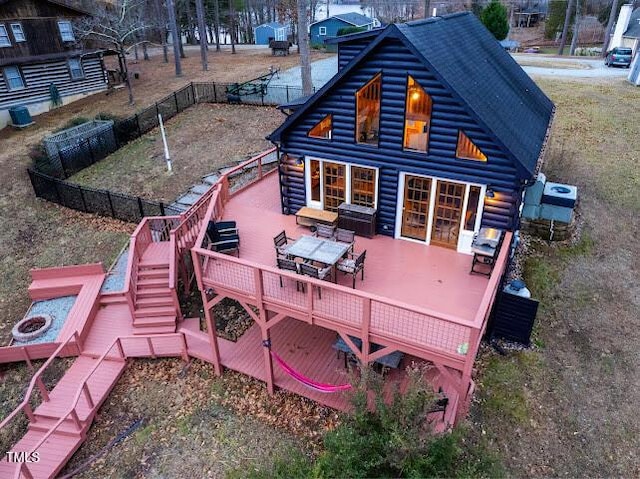 back of house with an outdoor fire pit and a deck