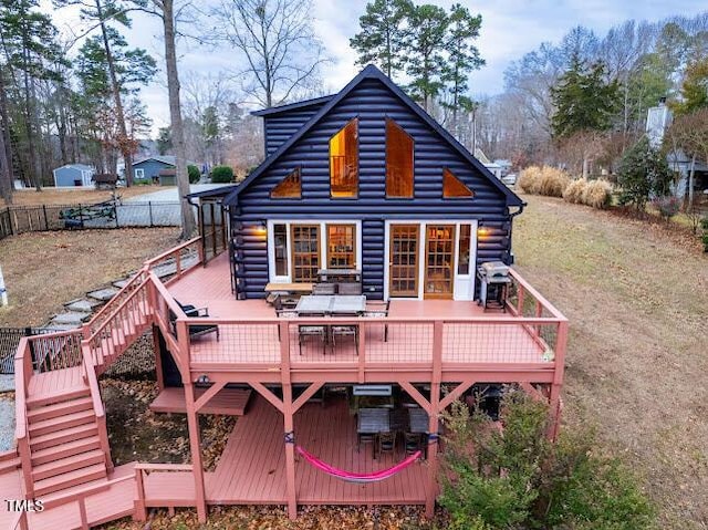 rear view of property with a lawn and a deck