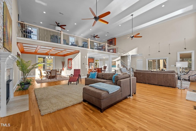 living room with an inviting chandelier, light hardwood / wood-style floors, and a high ceiling