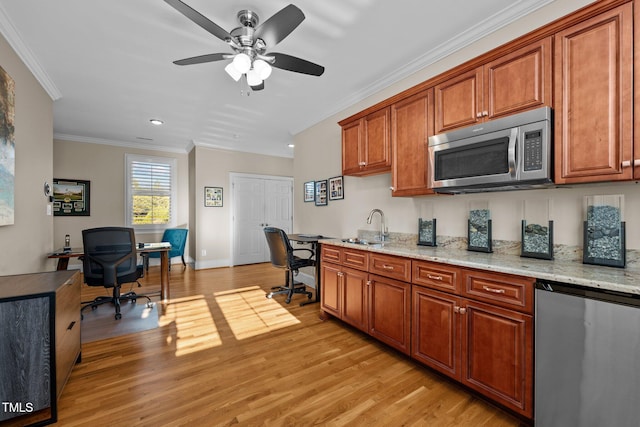 kitchen featuring fridge, ornamental molding, light stone counters, and light wood-type flooring