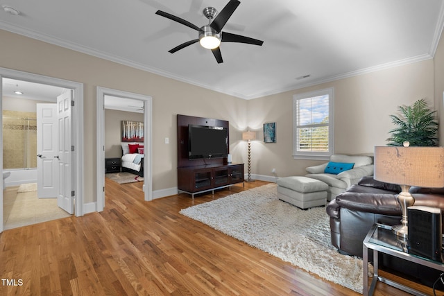 living room featuring wood-type flooring, ceiling fan, and crown molding