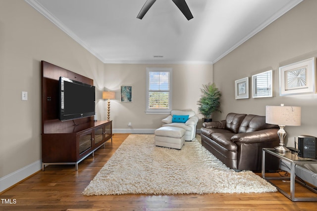 living room with crown molding, dark hardwood / wood-style floors, and ceiling fan