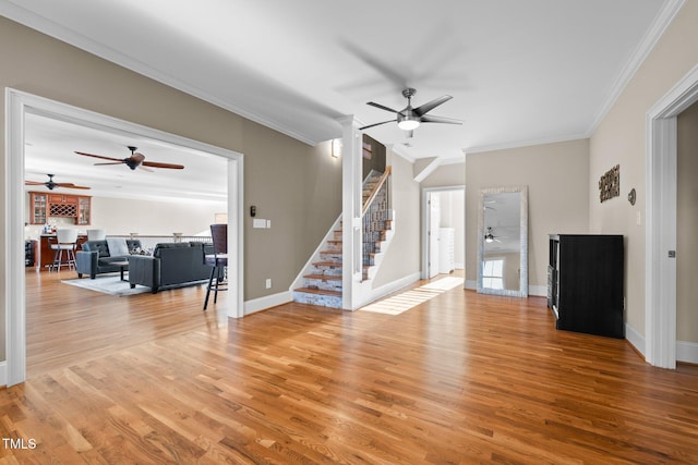 living room with crown molding, ceiling fan, and light wood-type flooring