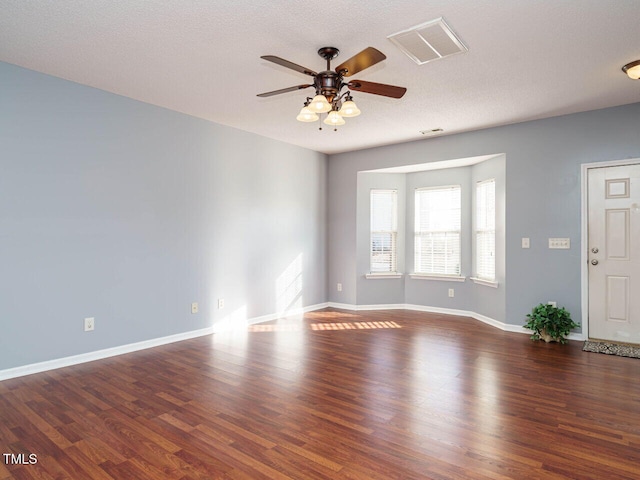 spare room with a textured ceiling, dark hardwood / wood-style floors, and ceiling fan