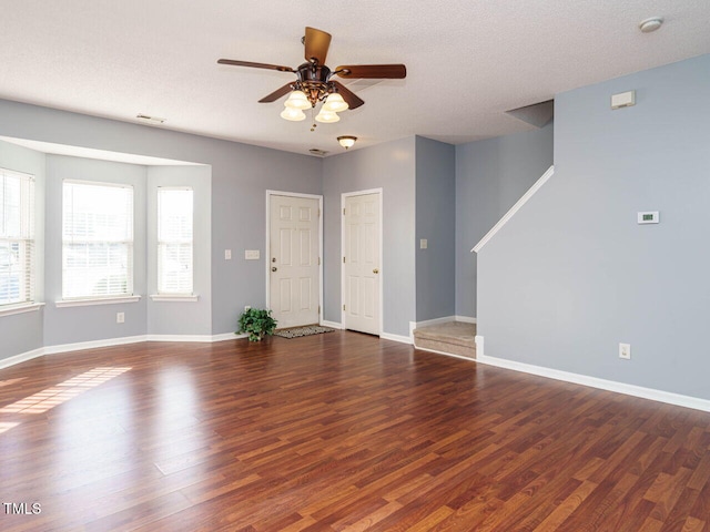 interior space with dark wood-type flooring, a textured ceiling, and ceiling fan