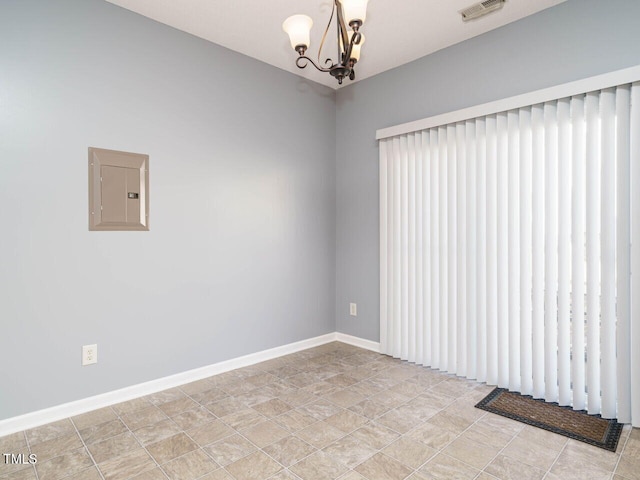 spare room featuring a chandelier and electric panel