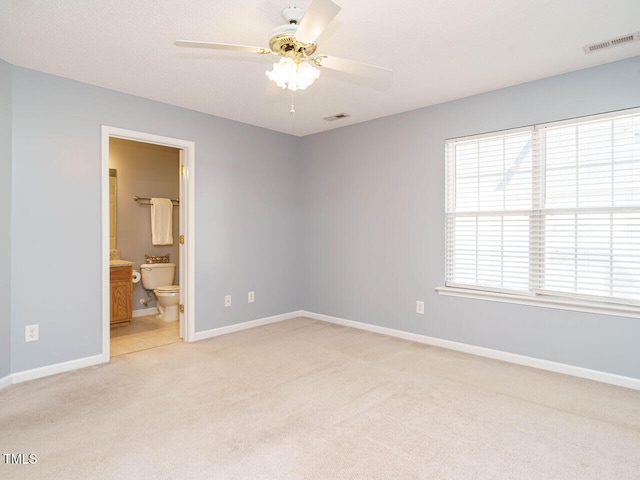 carpeted spare room featuring ceiling fan