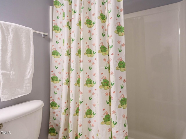 bathroom with toilet and a shower with shower curtain