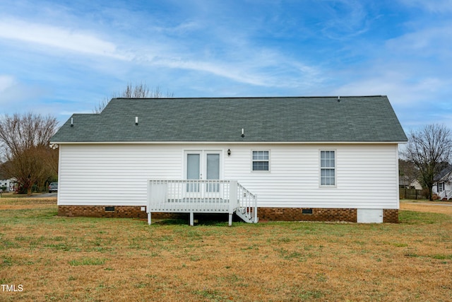 rear view of property with french doors, a deck, and a lawn