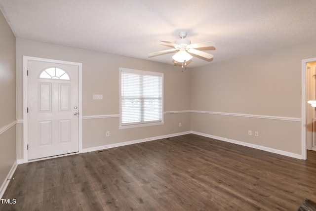 foyer entrance featuring dark hardwood / wood-style flooring, a textured ceiling, and ceiling fan