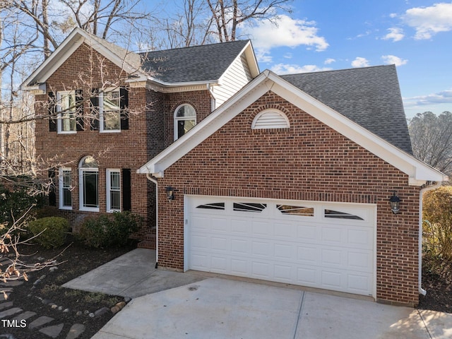 traditional-style home featuring a garage, concrete driveway, brick siding, and a shingled roof