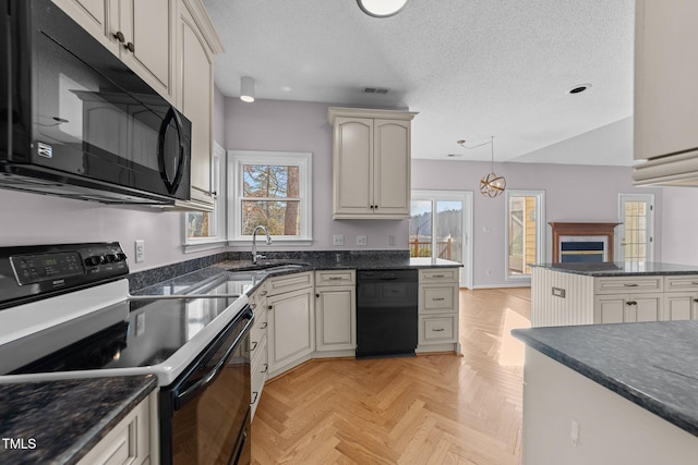 kitchen with a textured ceiling, a sink, visible vents, black appliances, and pendant lighting