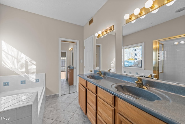 bathroom featuring a bath, visible vents, a sink, and tile patterned floors