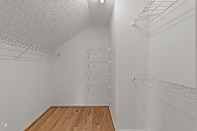 walk in closet featuring lofted ceiling and light wood-style flooring