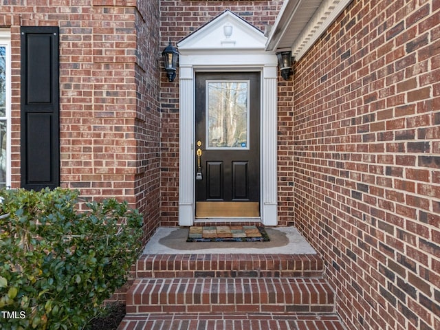 entrance to property featuring brick siding