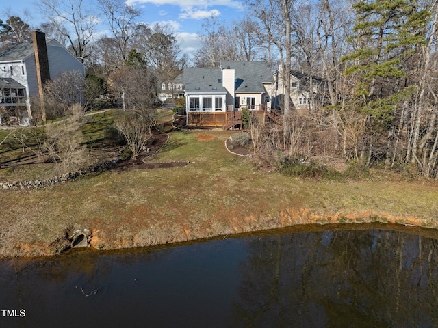 back of property with a sunroom and a deck with water view