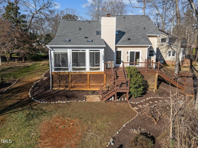 rear view of property featuring stairs, a yard, roof with shingles, a wooden deck, and a chimney