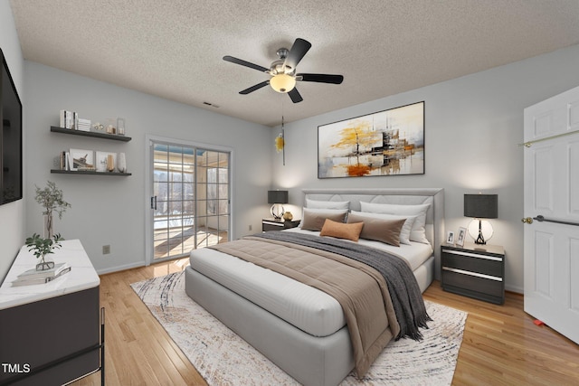 bedroom with light wood-type flooring, access to exterior, visible vents, and a textured ceiling