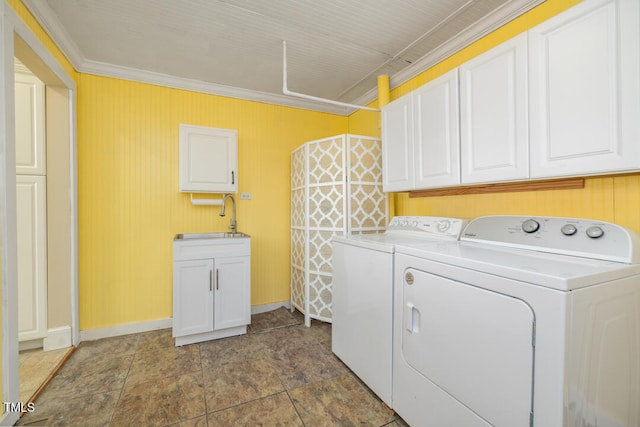 laundry area with sink, crown molding, washer and clothes dryer, and cabinets