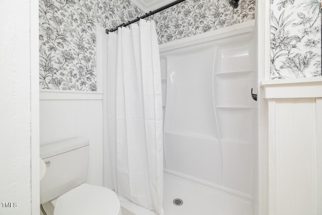 bathroom with a shower with curtain and toilet