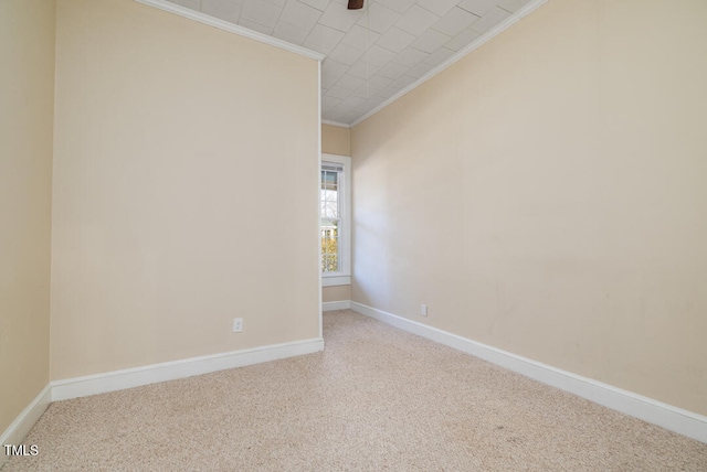 carpeted spare room featuring crown molding