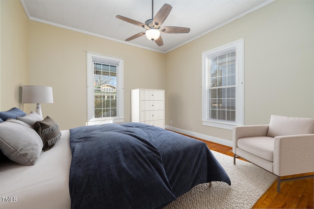 bedroom with crown molding, ceiling fan, and hardwood / wood-style floors