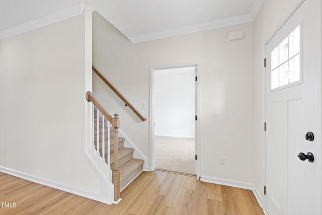 entryway featuring ornamental molding and light hardwood / wood-style flooring