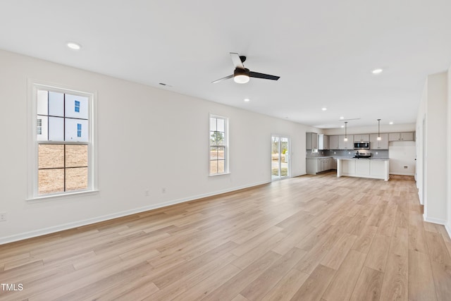 unfurnished living room featuring light hardwood / wood-style floors and ceiling fan