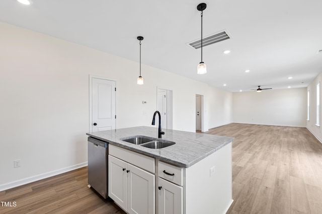 kitchen with sink, white cabinetry, a kitchen island with sink, light stone countertops, and stainless steel dishwasher