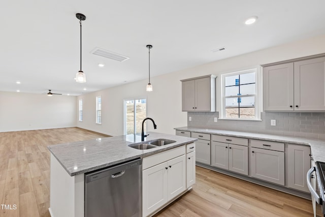 kitchen with sink, hanging light fixtures, gray cabinets, an island with sink, and dishwasher