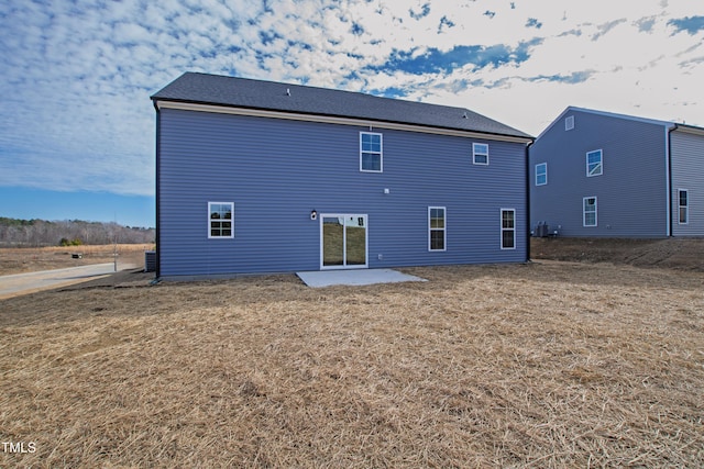 rear view of property featuring a lawn and a patio area