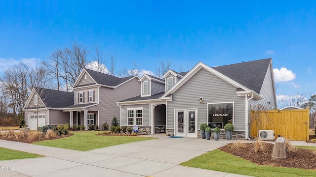 view of front of property with french doors, a garage, and a front lawn