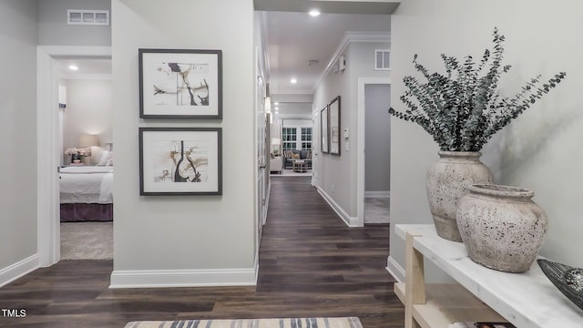 hall with ornamental molding and dark wood-type flooring