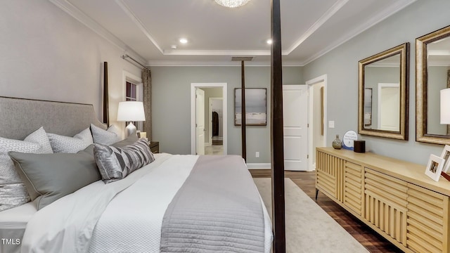 bedroom featuring crown molding, dark hardwood / wood-style floors, a raised ceiling, and ensuite bathroom