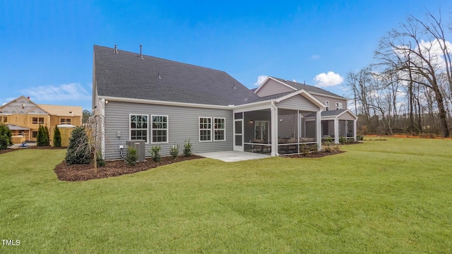 rear view of house with central AC, a sunroom, a lawn, and a patio area